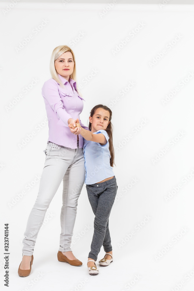 a portrait of the mother with her young daughter dancing on a white background a portrait of the mother with her young daughter dancing on a white background