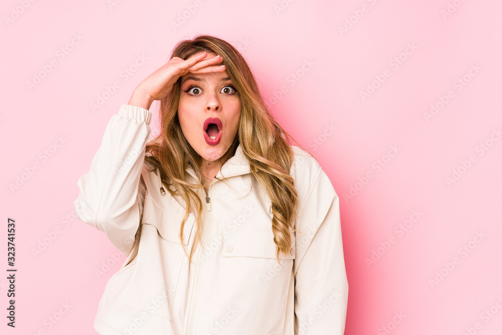 Young caucasian woman isolated on pink background looking far away keeping hand on forehead. Young caucasian woman isolated on pink background looking far away keeping hand on forehead.
