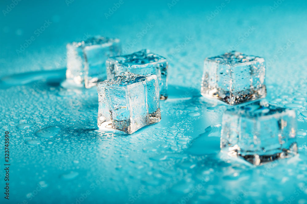 Ice cubes are scattered with water drops scattered on a blue background. Ice cubes are scattered with water drops scattered on a blue background.