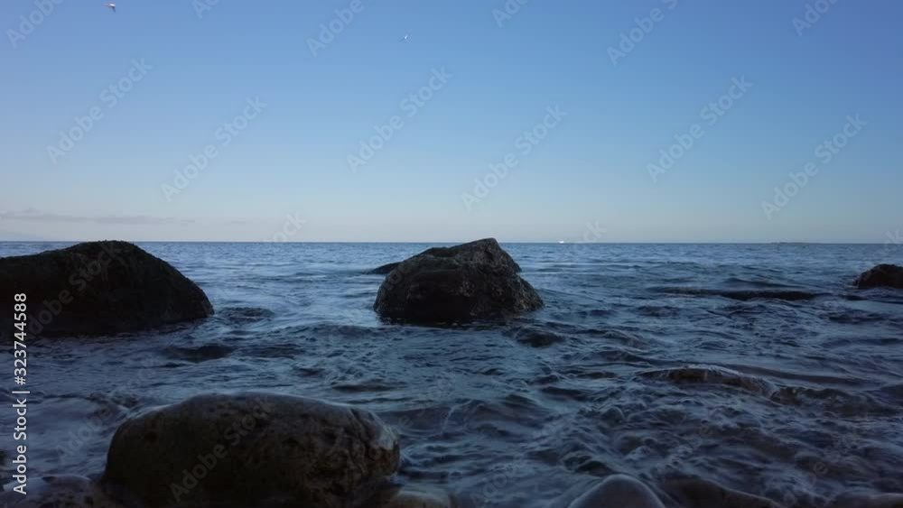 Mediterranean sea gently lapping rocks on the shore at Antibes, France. Mediterranean sea gently lapping rocks on the shore at Antibes, France.