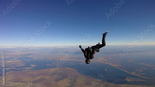 Student. Man in professional equipment hovers in the air. Skydiver studies the sky.