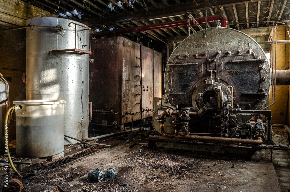 A rusty machine with water tank in an industrial setting A rusty machine with water tank in an industrial setting