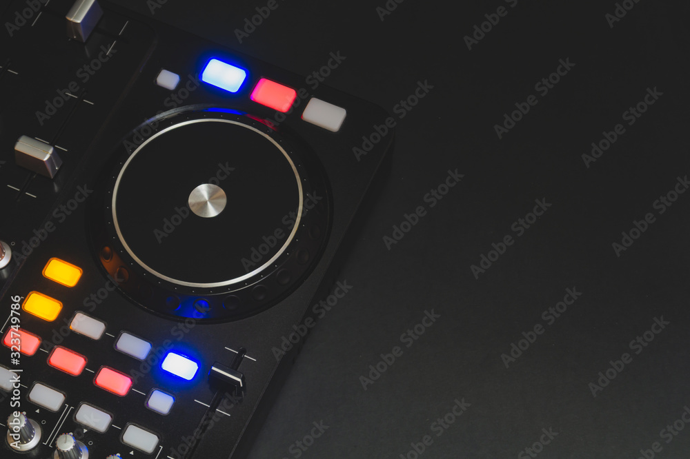 Dj sound mixer controller with knobs and sliders. audio mixing deck with turntables at dark with illuminated controls Dj sound mixer controller with knobs and sliders. audio mixing deck with turntables at dark with illuminated controls