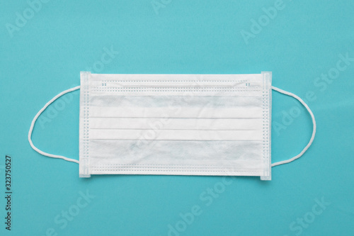 Protection against viruses and diseases, health products. White antibacterial medical mask on a blue background