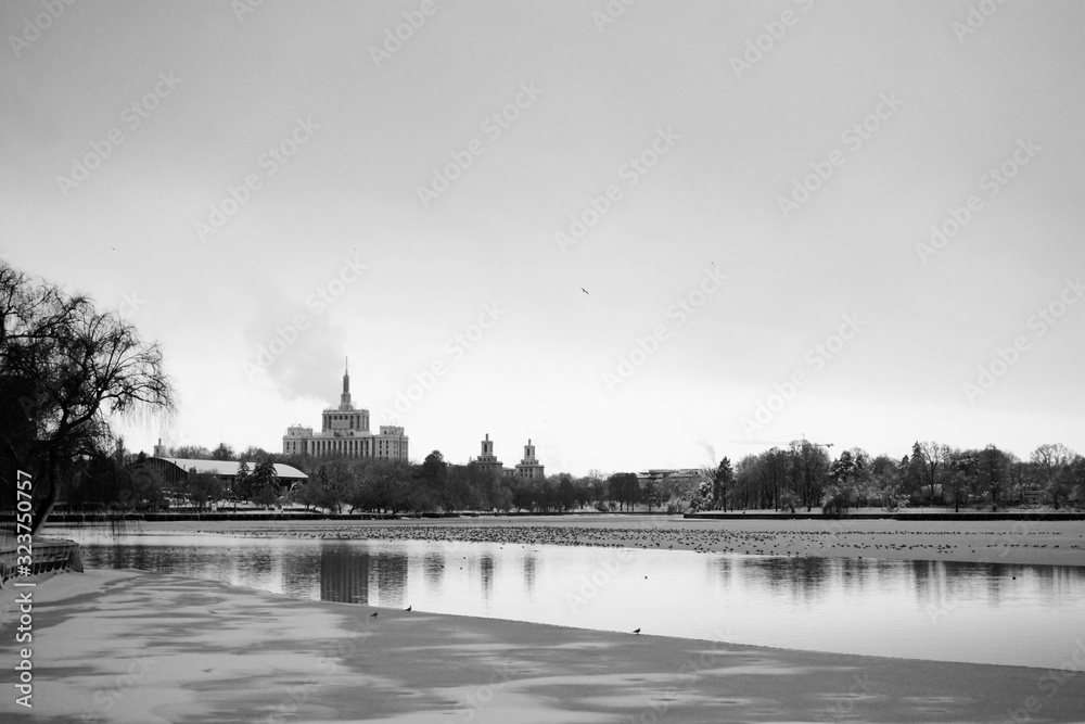Winter landscape. The city in winter viewed over the half frozen lake in Herastrau park in black and white.