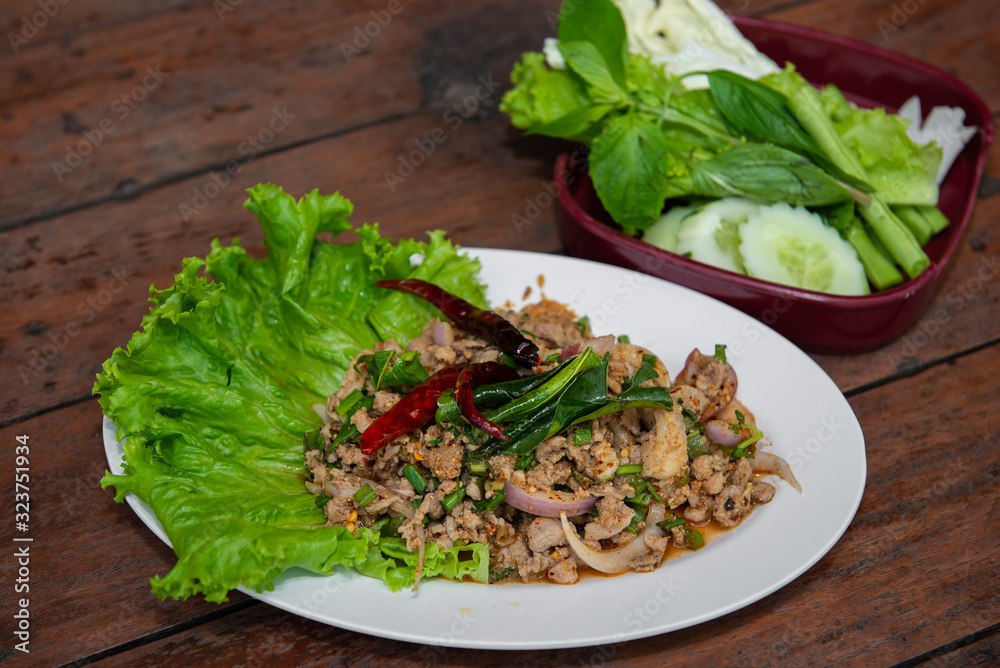 Spicy Minced Pork Salad with vegatable on the wood table Spicy Minced Pork Salad with vegatable on the wood table