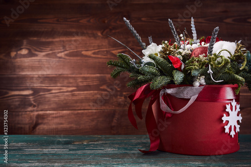 flowers in paper box on wooden background. Winter bouquet with fir branches.