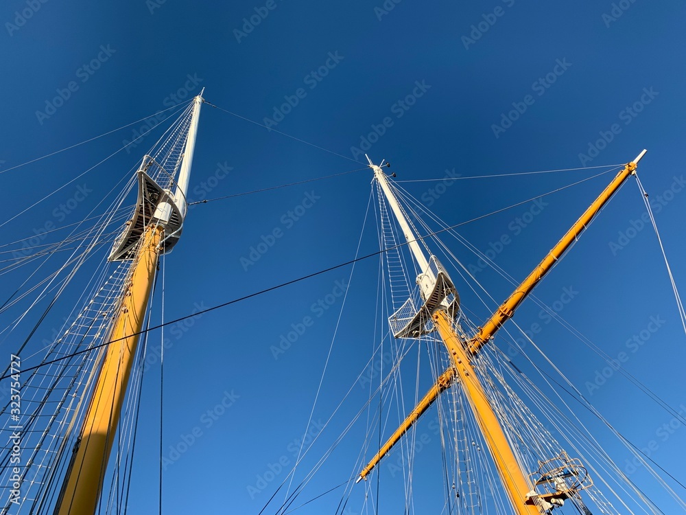 Wooden ship masts in the blue sky background Wooden ship masts in the blue sky background