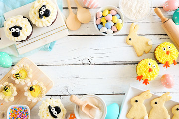 Easter table scene of mixed sweets and cookies. Above view frame over a white wood background. Spring holiday baking concept.