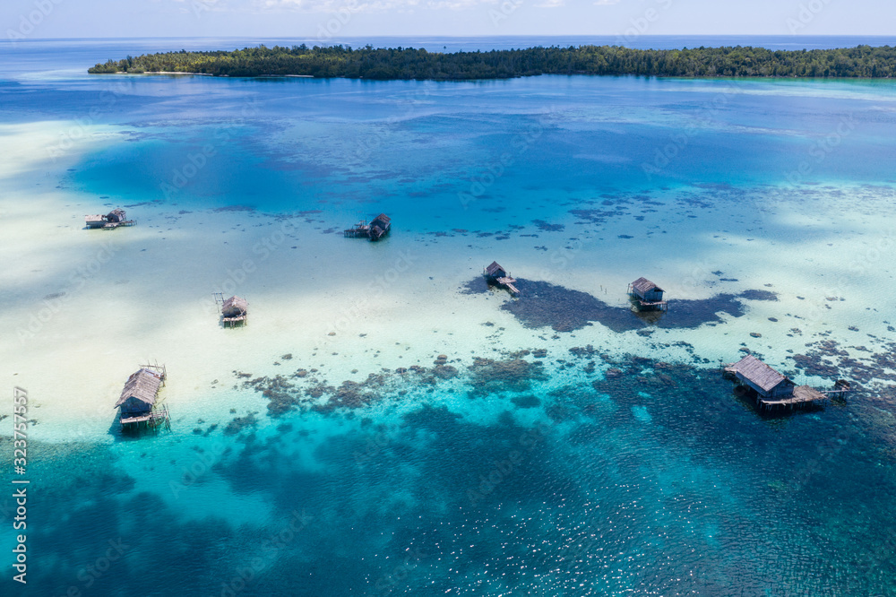 Fishing shacks are built on a remote reef in the Molucca Sea, Indonesia. This tropical region is known as the heart of the Coral Triangle due to its incredible marine biodiversity.