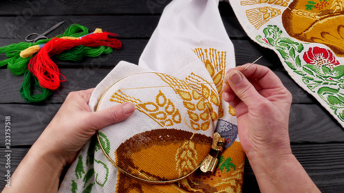 Fényképezés Female hands hold a needle with a thread and a hoop to fix the fabric in the pro