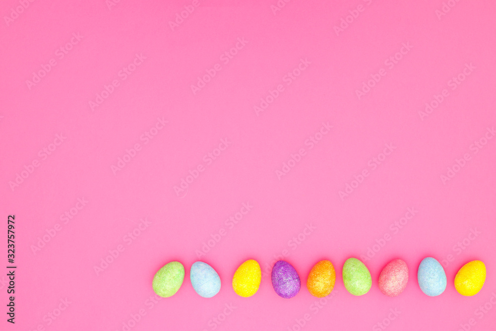 Easter pastel colored decorative eggs with glitter on color background 