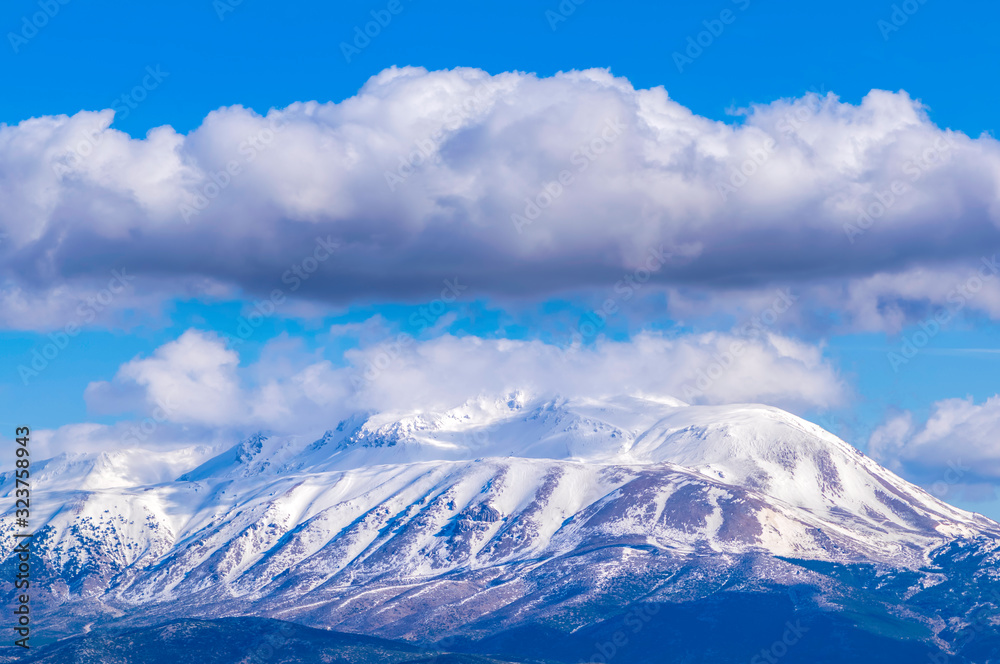 Snowy mountain with clouds, sunny winter day. Davraz Mountain at Isparta / Turkey.