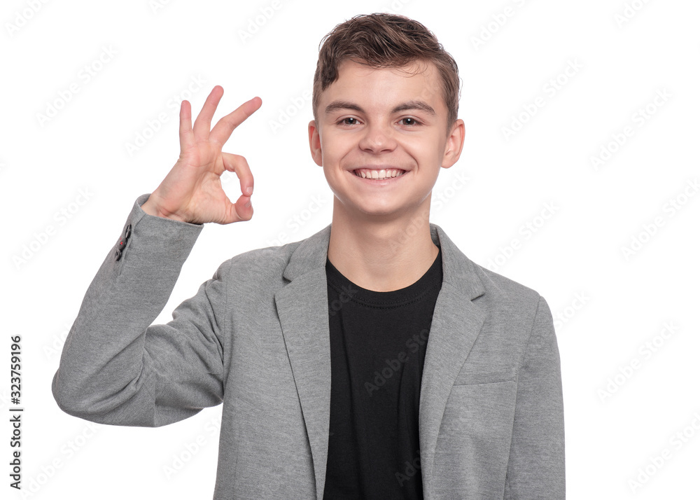 Handsome Teen Boy in suit making Ok Gesture. Portrait of caucasian Smiling Teenager isolated on white background. Happy child looking at camera. Handsome Teen Boy in suit making Ok Gesture. Portrait of caucasian Smiling Teenager isolated on white background. Happy child looking at camera.