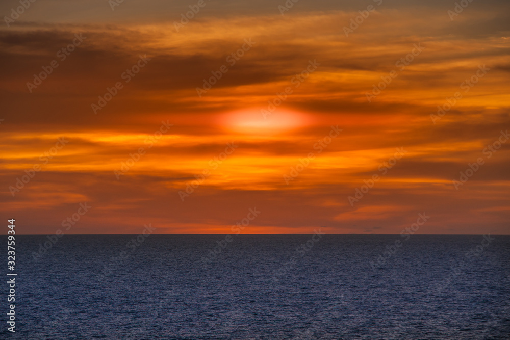 Timor Sea, Australai - December 1, 2009: Red sunset with brown cloudscape over dark blue sea. 