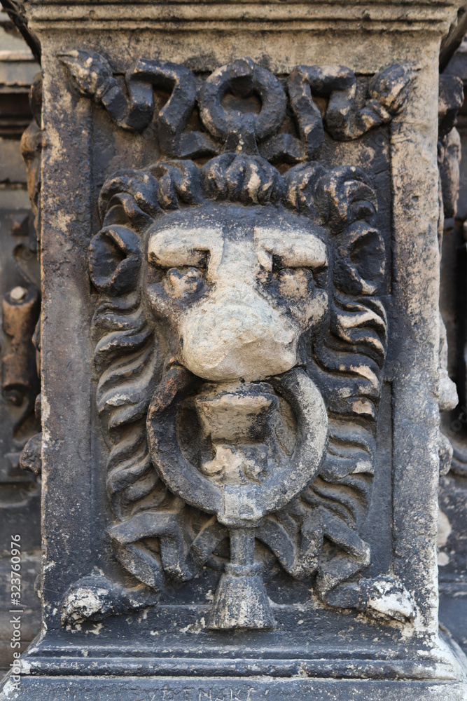 Architectural detail in the form of lion’s muzzle. Ancient architecture. Ruins of temples and castles sooty from age. Damaged by time