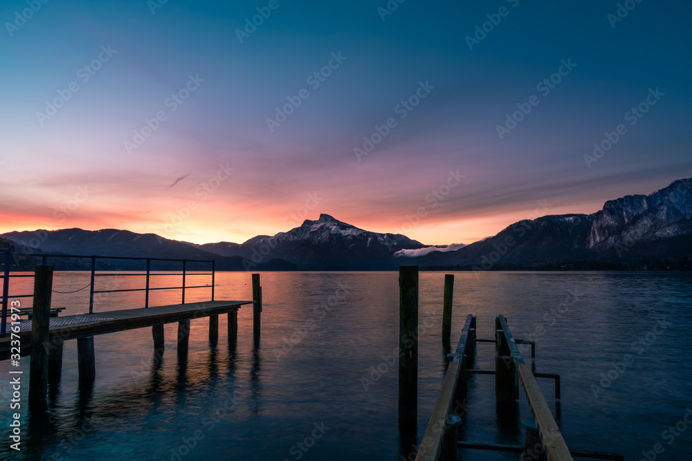 sunrise at the lake on a pier with panorama view to the mountains