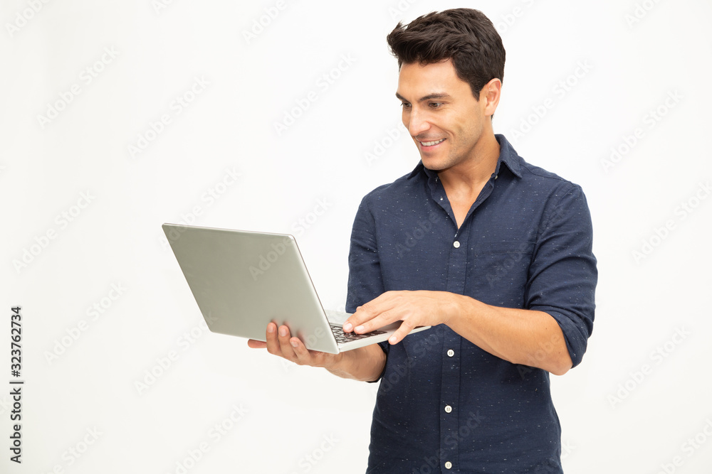 Portrait of an excited man holding laptop computer and celebrating success over white background, Raising arms with a look of happiness, Male model Portrait of an excited man holding laptop computer and celebrating success over white background, Raising arms with a look of happiness, Male model