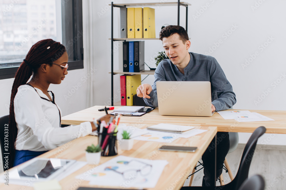 Young African beautiful woman having an interview or business meeting with employer. Employer examining in a modern office interior Young African beautiful woman having an interview or business meeting with employer. Employer examining in a modern office interior