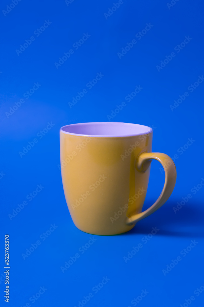 Obraz premium Yellow color big mug over blue background.