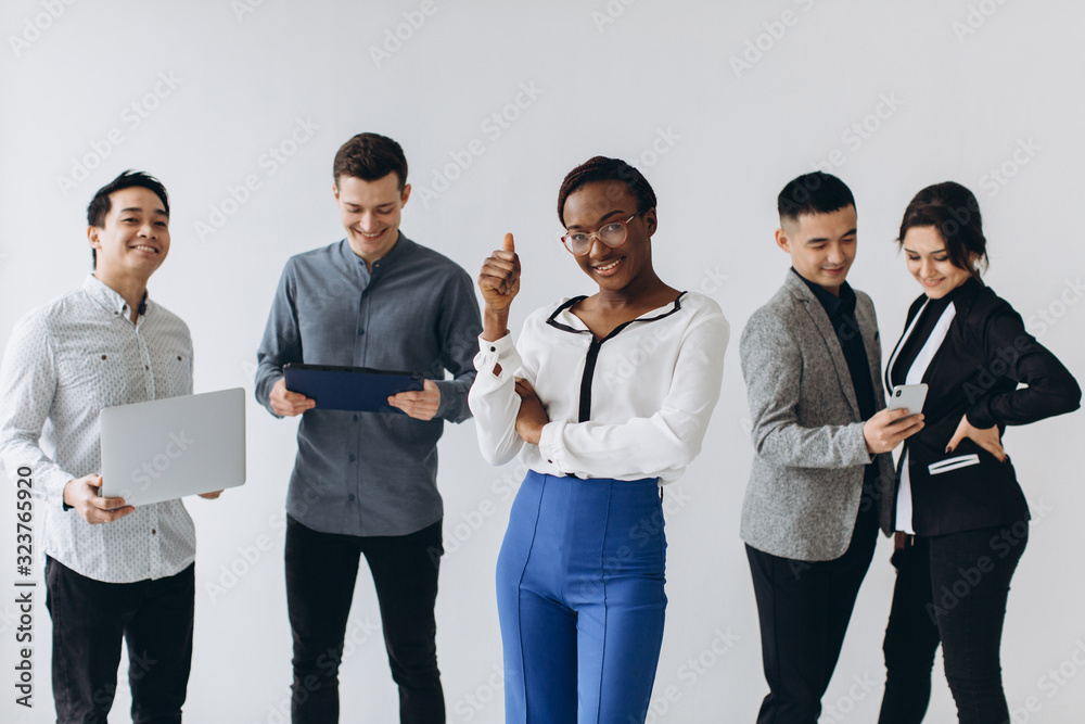 Group of multicultural young executive people standing and busy using smartphones for work in the office. Social media technology and online business with teenager lifestyle concept Group of multicultural young executive people standing and busy using smartphones for work in the office. Social media technology and online business with teenager lifestyle concept