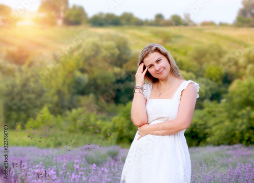 woman in a white sundress walks in a lavender field and rests