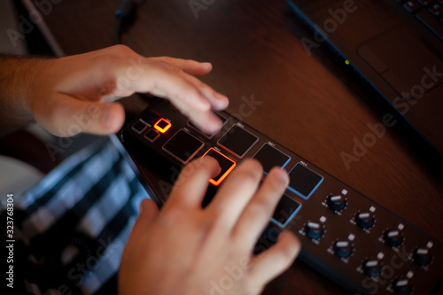 a man plays electronic pads and drum machine with his fingers