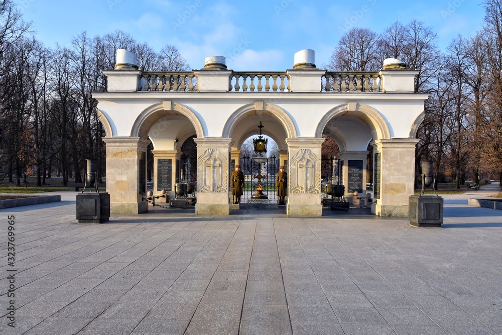 Obraz premium Warsaw, Poland - January 2020. Elegant white colonnade with eternal flame on the tomb of the unknown soldier. Monument in honor of Second World War. View from the Pilsudski Square. 