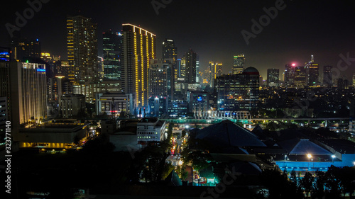 Modern buildings of Jakarta with lights at night on background, view from Kuningan Jakarta, Indonesia