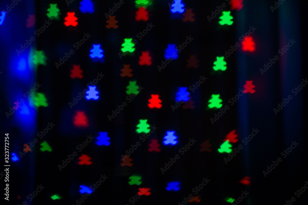 Beautiful bokeh in the form of bears of different colors on a dark background Beautiful bokeh in the form of bears of different colors on a dark background