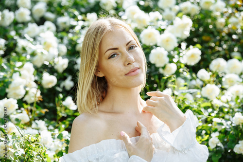 Foto girl in a white dress in the garden with white roses