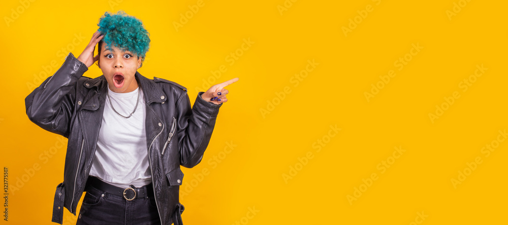 young afro american girl isolated on color background pointing space