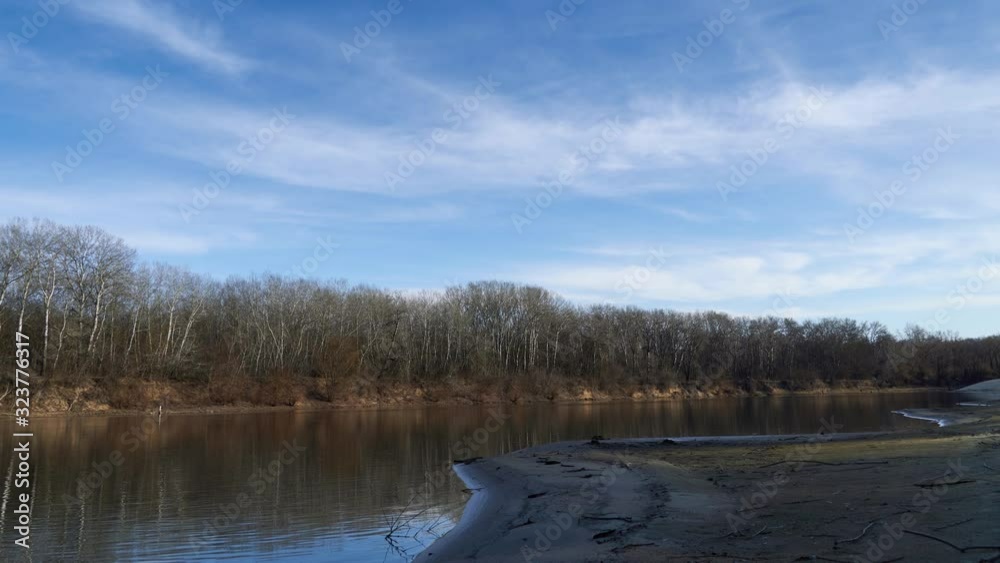 Timelapse of Bright beautiful spring landscape - forest, river and blue sky with soft clouds Timelapse of Bright beautiful spring landscape - forest, river and blue sky with soft clouds