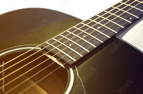 part of an acoustic guitar on white. Close-up. Image is tinted.