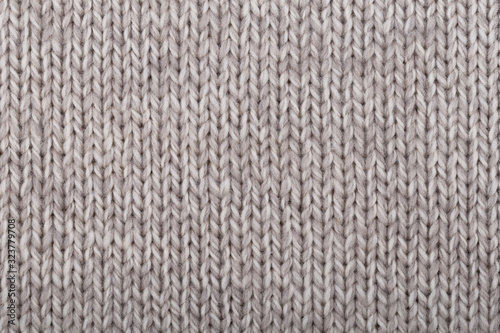 Knitted natural brown wool texture as background.Close up.Concept for knitting cozy sweaters, warm winter knitted clothes, patterns.