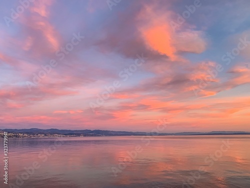 Tender pink sunset at the sea, pink flower reflection on the sea