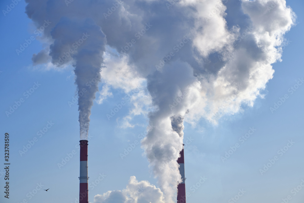 White from factory pipes against a blue sky, a symbol of air pollution, environmental degradation White from factory pipes against a blue sky, a symbol of air pollution, environmental degradation