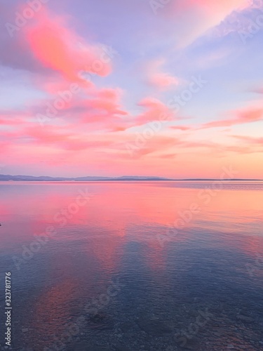 Gartenposter Zarter rosa Sonnenuntergang am Meer, rosa Blumenreflexion auf  dem Meer