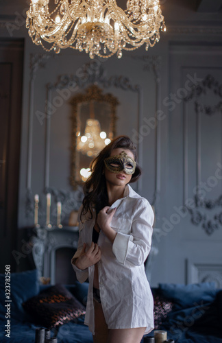 Beautiful sexy girl in carnival mask and white shirt in a classic interior.. © fotoplaton