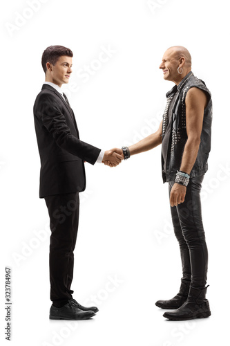 Young man in a suit shaking hand with a punk in leather clothes