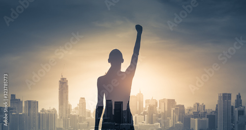 Fotografia confident young woman with fist in the air facing the city