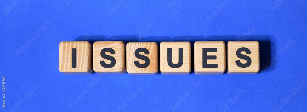 ISSUES text on wooden cubes on a blue background