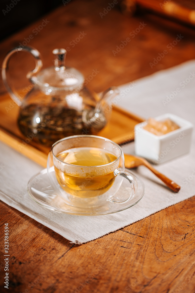 Cup of hot tea with rock sugar, dry tea leaves served in thermo glass tea cup Cup of hot tea with rock sugar, dry tea leaves served in thermo glass tea cup