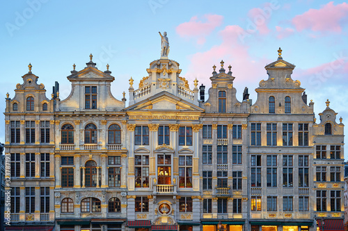 Brussels Grand Place. North-east part. Sunset evening view of row of old beautiful stone buildings facades between Rue de la Colline and Rue des Harengs. Lots of artistic golden details and photo