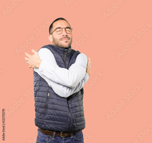 Happy young man doing a hug gesture