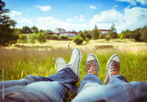 Couple sitting on park grass relaxing together in a beautiful country setting. 
