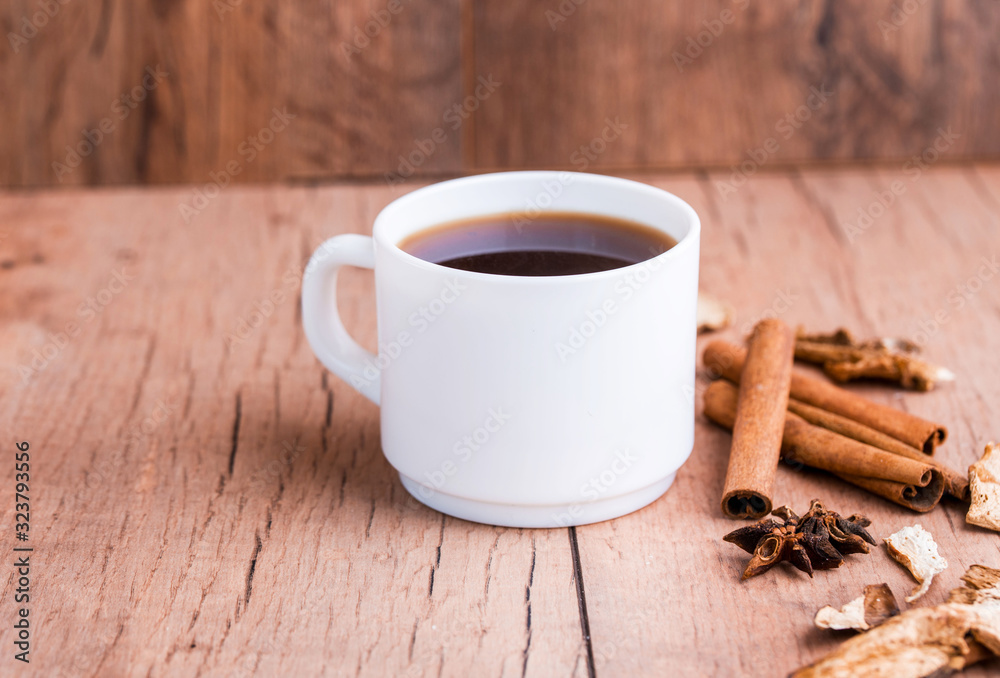 Fragrant natural custard coffee with cinnamon sticks, dried mushrooms, on a wooden background.