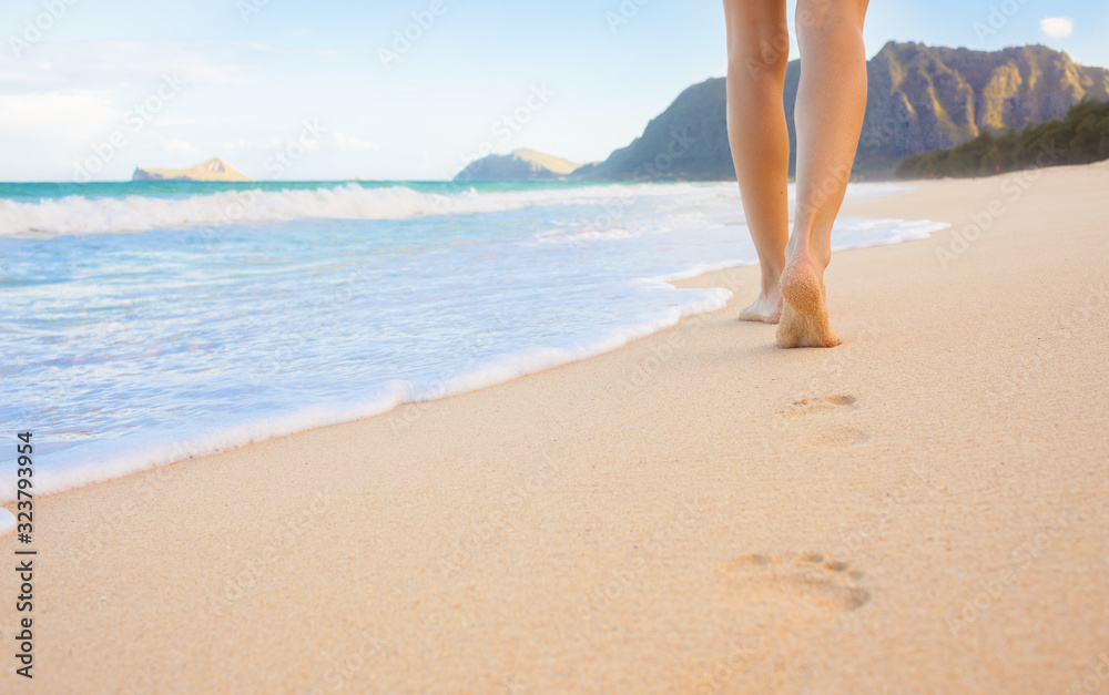 Female walking barefoot on white sand beach leaving footprints in the sand. Location Hawaii. Female walking barefoot on white sand beach leaving footprints in the sand. Location Hawaii.