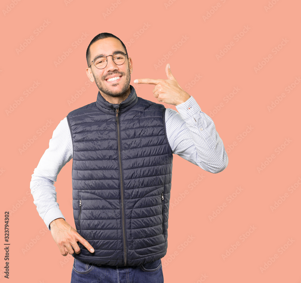 Young man pointing to his teeth Young man pointing to his teeth