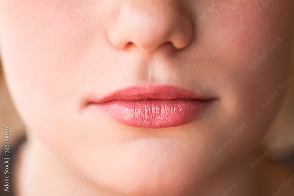 Fototapeta premium Young attractive teenager girl's face view with lipstick on lips
